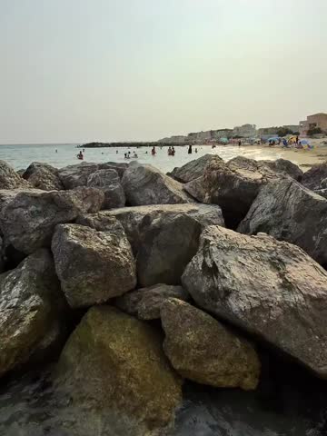 Rocky beach with bathers in the distance
