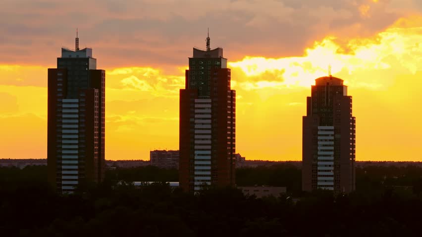 Golden sunset silhouette reveals Riga’s modern skyline in calm cinematic glide