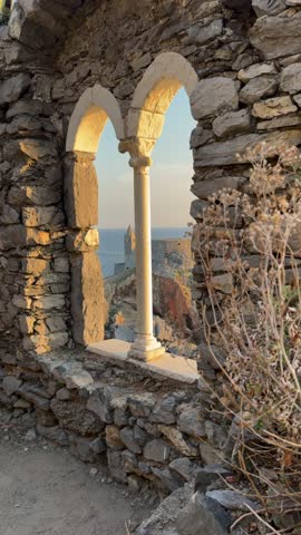 Video from a picturesque spot in Portovenere through an ancient stone window framing the Ligurian Sea at sunset 