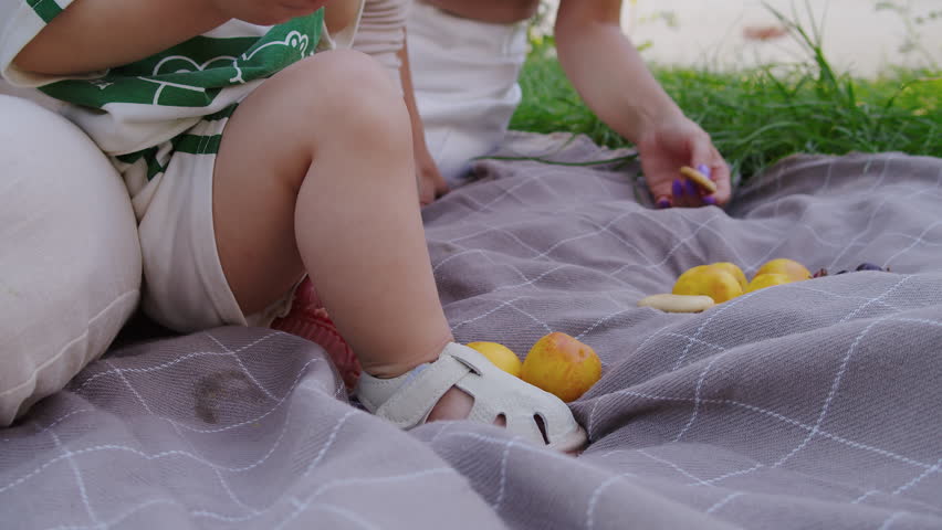 Baby sitting on blanket with fruits