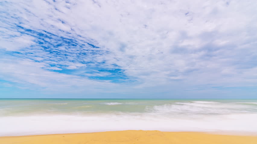 Beautiful sandy beach with blue sky white clouds moving over sea, Tropical beach with waves crashing on an empty beach, Dramatic Time Lapse Sunny clouds over ocean sea,Nature summer background