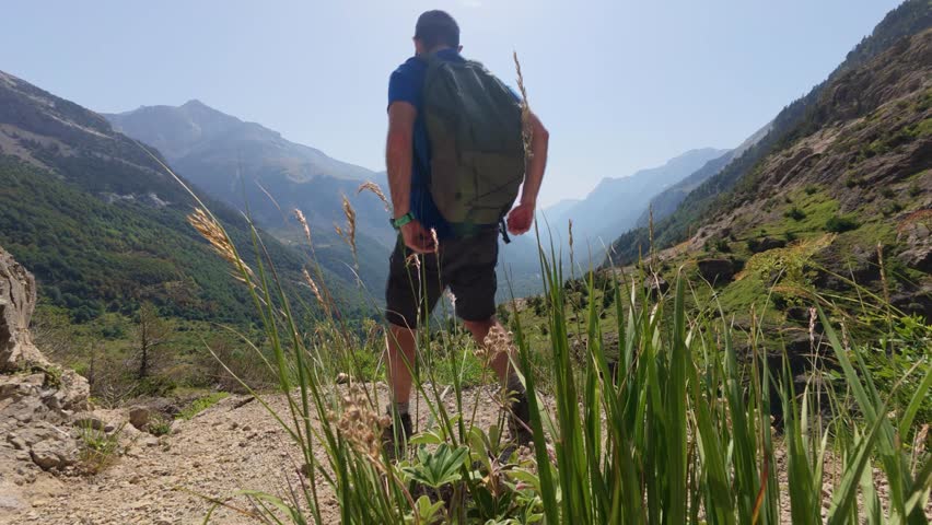 Young man reaching the viewpoint with spectacular views of the Llanos de la Larri and the entire Pineta valley, impressive panorama in the Ordesa y Monte Perdido National Park in 4K.