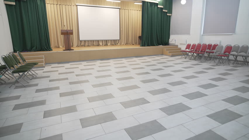 Event room with open stage curtains along with projector backdrop. Space blends stage tech and seating into functional organized design