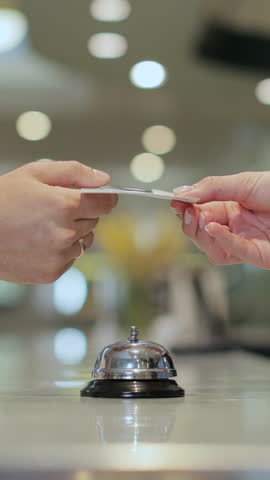 Vertical Video Close up of businesswoman hands getting room key at hotel reception. Hotel service.