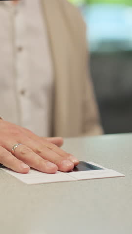 Vertical Video Close up of businessman hands getting room key at hotel reception. Hotel service.