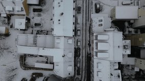 An overhead view reveals an almost abstract winter cityscape, where stark white snow on rooftops and the ground forms clean lines and geometric shapes that contrast with dark roads - Powered by Shutterstock - Get 15% off with code: PIKWIZARD15