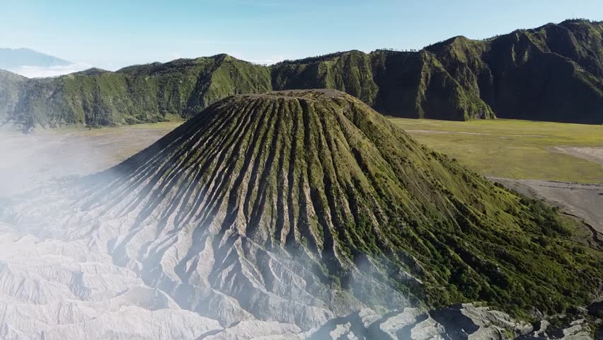 Cinematic HD drone shot approaching Mount Batok in Java. The inactive volcano displays dramatic ridges and textures, offering a stunning natural aerial perspective.