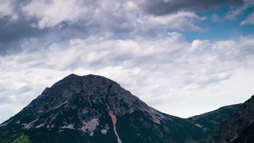 Scenic mountain peak with rocky terrain under cloudy sky in the alps
