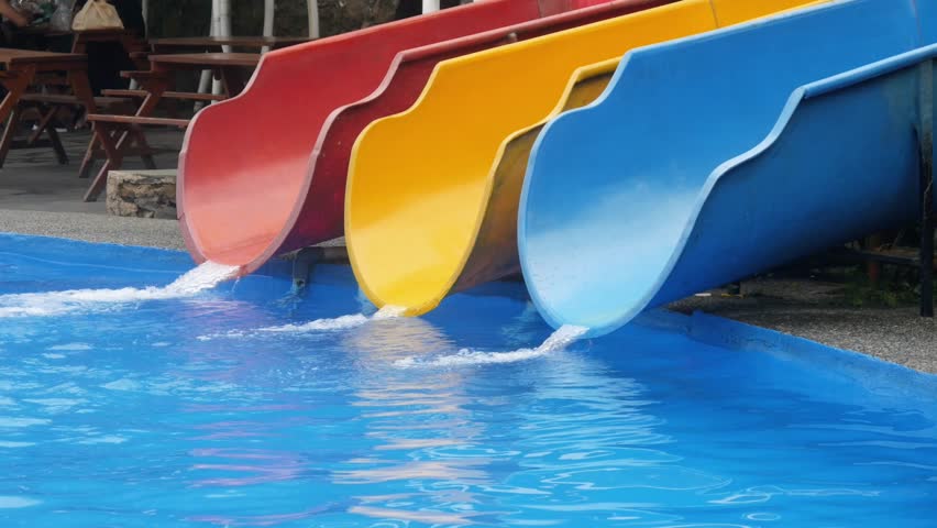Three parallel water slides in red, yellow, and blue lead down to the pool. Water flows from the end of the slides into the clear blue pool, creating a fresh and fun atmosphere.