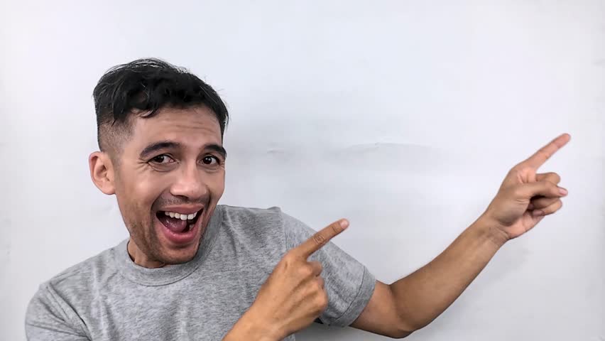 A joyful man points enthusiastically towards a blank space, perfect for advertisement. - Powered by Shutterstock - Get 15% off with code: PIKWIZARD15