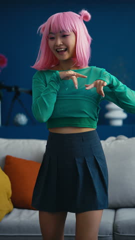 Happy k-pop blogger with pink hair practicing dance at home, Korean wave fan