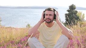 Handsome man listening to music with his headphones in natural setting  - Powered by Shutterstock - Get 15% off with code: PIKWIZARD15