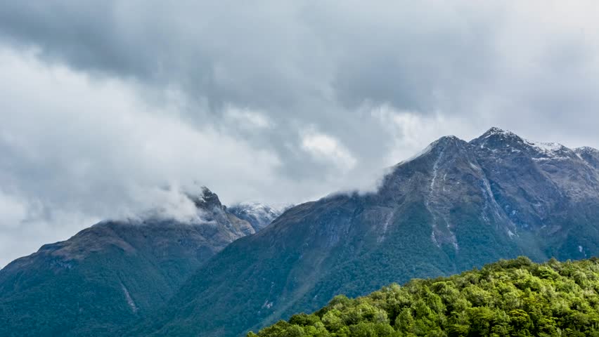 Wide view of a wooded hill with lush summer vegetation under a lightly clouded sky near Christchurch, New Zealand.