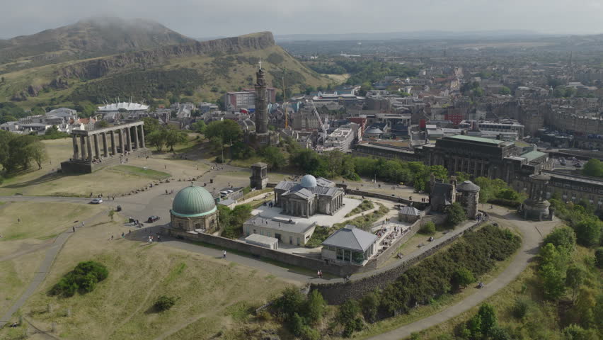 Establishing aerial view of Edinburgh showing Calton Hill with the National Monument of Scotland, Nelson Monument and Dugald Stewart Monument. Capital of Scotland, United Kingdom