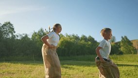 Children jumping in sack race outdoors. Boy and girl play summer game. Active children outdoors having fun competition. Summer competition spirit for every child. Jumping joy in nature for kids. - Powered by Shutterstock - Get 15% off with code: PIKWIZARD15