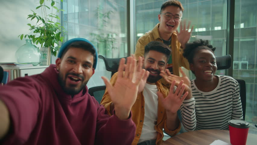 Four diversity colleagues startup workers in office multiracial informal business team happy talking smiling greeting to vlog video call welcome come here conference mobile phone web cam point of view
