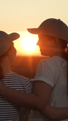 Mother child hugging on sunny day. Happy family walking in field looking in sun. Carefree childhood of mother child. Happy daughter hugging her mom on street. Girl daughter hug her mother summer park