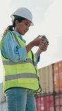 Vertical Video. Woman Using Remote Controller To Navigate Drone Outside The Warehouse Area. Cargo Centre Employee Inspecting Containers With Drone Outdoors. Container Import And Logistics Concept - Powered by Shutterstock - Get 15% off with code: PIKWIZARD15