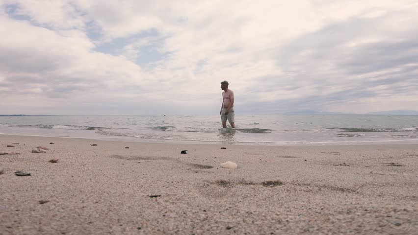 Man tourist enjoy walk on the beach on sunny hot summer day