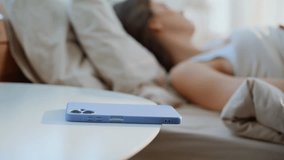 Morning woman reaching to smartphone turning off alarm in light bedroom closeup. Sleepy lady taking cellphone checking time in modern apartment. Lazy brunette waking up lying on comfortable soft bed. - Powered by Shutterstock - Get 15% off with code: PIKWIZARD15