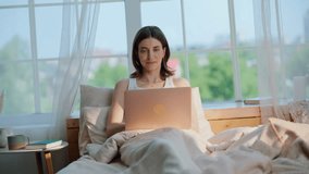 Businesswoman looking laptop in bedroom relaxing on cozy white bedding. Relaxed woman drinking morning coffee browsing computer in home bed. Beautiful lady sipping beverage working online in bedroom. - Powered by Shutterstock - Get 15% off with code: PIKWIZARD15
