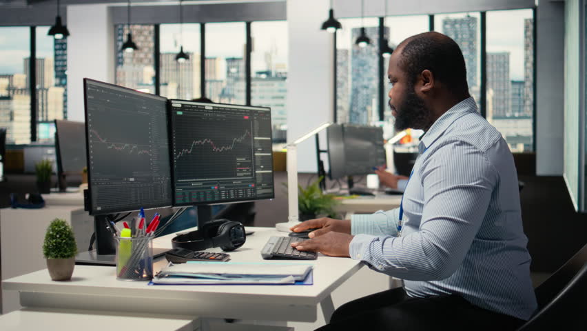 Trader frightened by security alert on PC after hacker uses exploit to penetrate systems. Brokerage company worker responds to cyberattack, protecting client account from unauthorized access, camera A