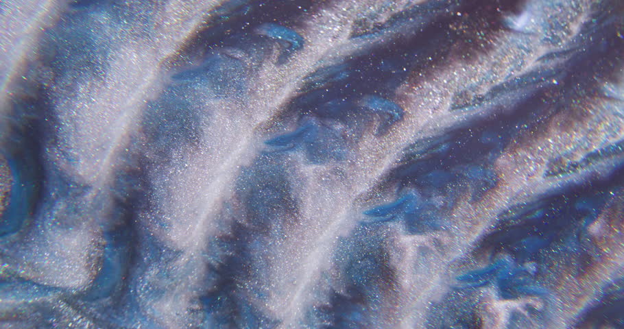 Sparkling paint. Flow particles. Defocused blue silver purple color wave glitter liquid floating on abstract light creative background.