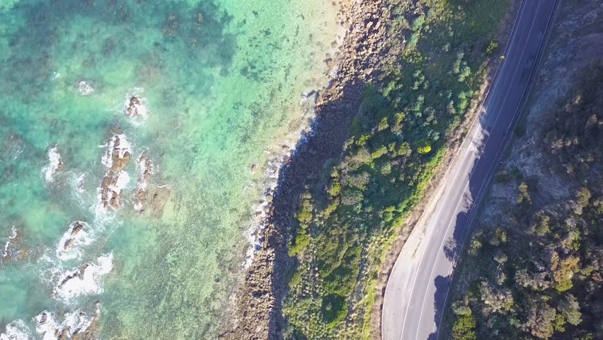 Drone footage of the Great Ocean Road in Victoria, highlighting rugged cliffs, blue ocean waves, and green forest along Australia’s famous coastal drive - DLOG Flat File 4K