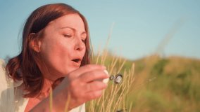 Close up woman blowing delicate soap bubbles that drift then burst in golden sunset light over grassy hill, rainbow sheen shimmering before popping gently against blurred - Powered by Shutterstock - Get 15% off with code: PIKWIZARD15
