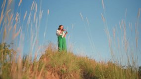 Woman standing on grassy hilltop near cliff blowing delicate soap bubbles into clear blue sky, green dress fluttering in breeze as sunlight warms landscape and bubbles catch rainbow reflections - Powered by Shutterstock - Get 15% off with code: PIKWIZARD15