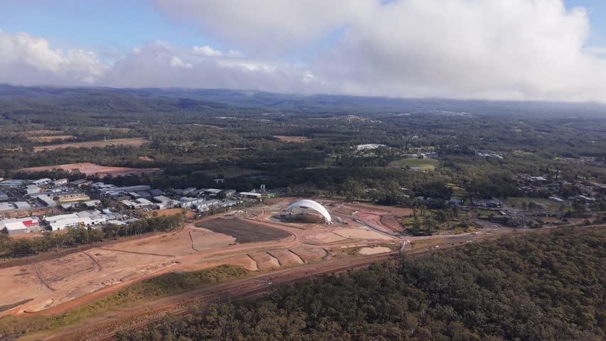 Aerial establishing approach to Cedar Mill abandoned stadium site with dirt roads and unfinished work