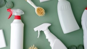 White spray bottles and cleaning brush arranged on a plain green background with greenery details - Powered by Shutterstock - Get 15% off with code: PIKWIZARD15