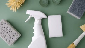 White spray bottle with cleaning sponges and brushes on green background - Powered by Shutterstock - Get 15% off with code: PIKWIZARD15