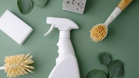 White spray bottle with cleaning brushes and sponges arranged on a green surface with leaves. - Powered by Shutterstock - Get 15% off with code: PIKWIZARD15