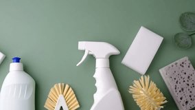 White spray bottle, brushes, and sponges for home cleaning on green background. - Powered by Shutterstock - Get 15% off with code: PIKWIZARD15