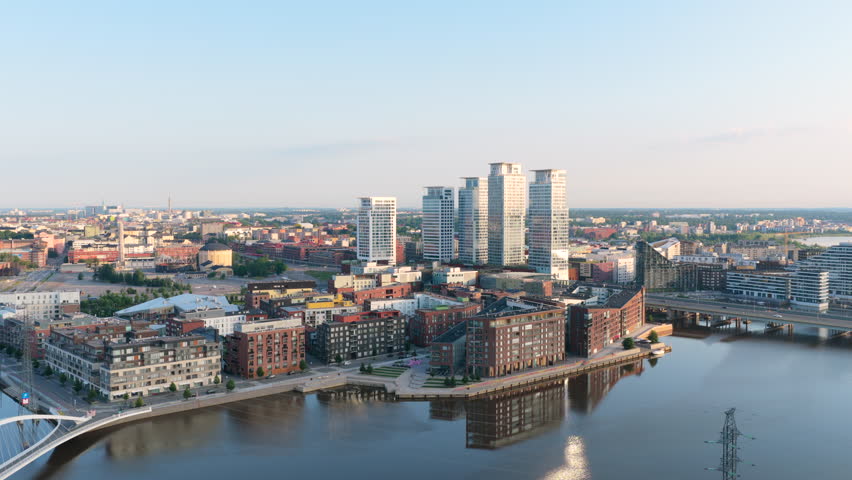 Drone circling the Kalasatama district with high-rise, golden hour in Helsinki