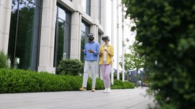 A man and a woman wear VR headsets and walk outdoors. The man holds a coffee cup, and the woman holds a phone. - Powered by Shutterstock - Get 15% off with code: PIKWIZARD15