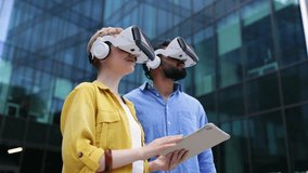 A man and a woman wearing VR headsets and interacting with virtual reality outdoors, with a tablet. - Powered by Shutterstock - Get 15% off with code: PIKWIZARD15