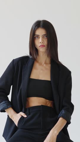 Fashion model posing in black suit on white background slow motion