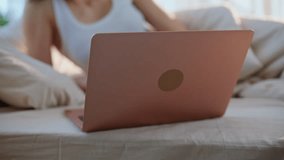 Brunette talking virtual meeting by laptop relaxing in comfortable home bed closeup. Smiling woman gesturing enjoying friendly video call in bedroom. Attractive lady speaking at online conference. - Powered by Shutterstock - Get 15% off with code: PIKWIZARD15