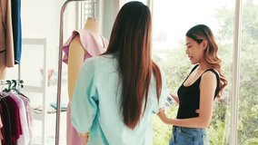 Two young women laugh while shopping in a bright boutique, picking a pink dress from a rack. Casual retail moment with fashion, clothing, apparel, garments, hangers, and friendly styling. - Powered by Shutterstock - Get 15% off with code: PIKWIZARD15
