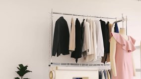 Two young fashion designers collaborate in bright studio. Tailoring teamwork at boutique startup with fabric, patterns, garments, mannequins, and rack. Seamstress entrepreneur spirit shown. - Powered by Shutterstock - Get 15% off with code: PIKWIZARD15