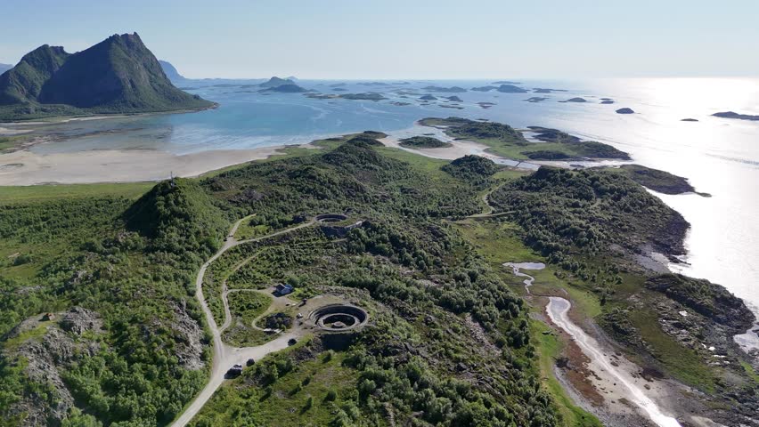Aerial footage of Batterie Dietl on Engeløya, Norway. A historic World War II site now set on a peaceful island, surrounded by mountains and lapped by the sea