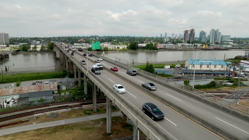 Vehicles Travel Across the Oak Street Bridge Over the Fraser River in Richmond, British Columbia, Canada - Aerial Drone Shot