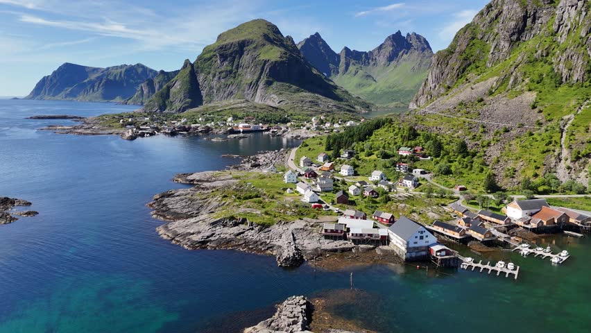 Aerial footage of the fishing village Å, nestled between steep mountains with scenic coastlines in the Lofoten Islands, Norway.