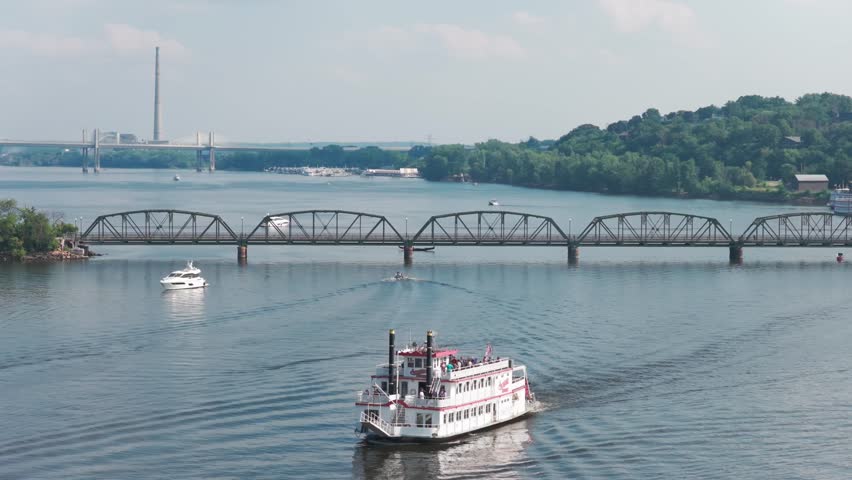 Telephoto panning close-up aerial shot of a riverboat near the St. Croix River lift bridge in Stillwater, Minnesota. 4K