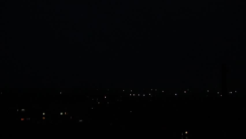 Dramatic Lightning Strike on a City Tower. Purple Sky at Night. City Nightlife Interrupted. Lightning Hits a Transformer and Causes a Power Flash.