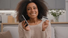 Happy joyful African American woman girl female shopping online at home with mobile phone and credit card bank service ordering food delivery purchasing goods with smartphone e-commerce app using - Powered by Shutterstock - Get 15% off with code: PIKWIZARD15
