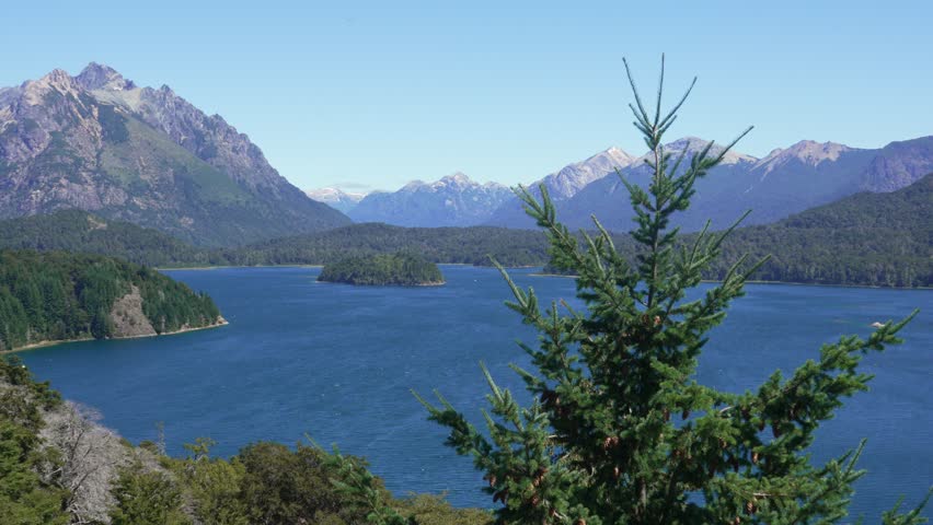 Static shot from a viewpoint on Circuito Chico overlooking Lake Perito Moreno with forests, islands, and the Andes mountain range. Nahuel Huapi National Park, Bariloche, Patagonia, Argentina
