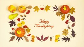 Happy Thanksgiving Greeting Card. Beautiful frame of autumn leaves, orange pumpkins, ripe apples, pears, rowan berries and acorns. Light yellow background. Stop motion animation. Flat lay. - Powered by Shutterstock - Get 15% off with code: PIKWIZARD15